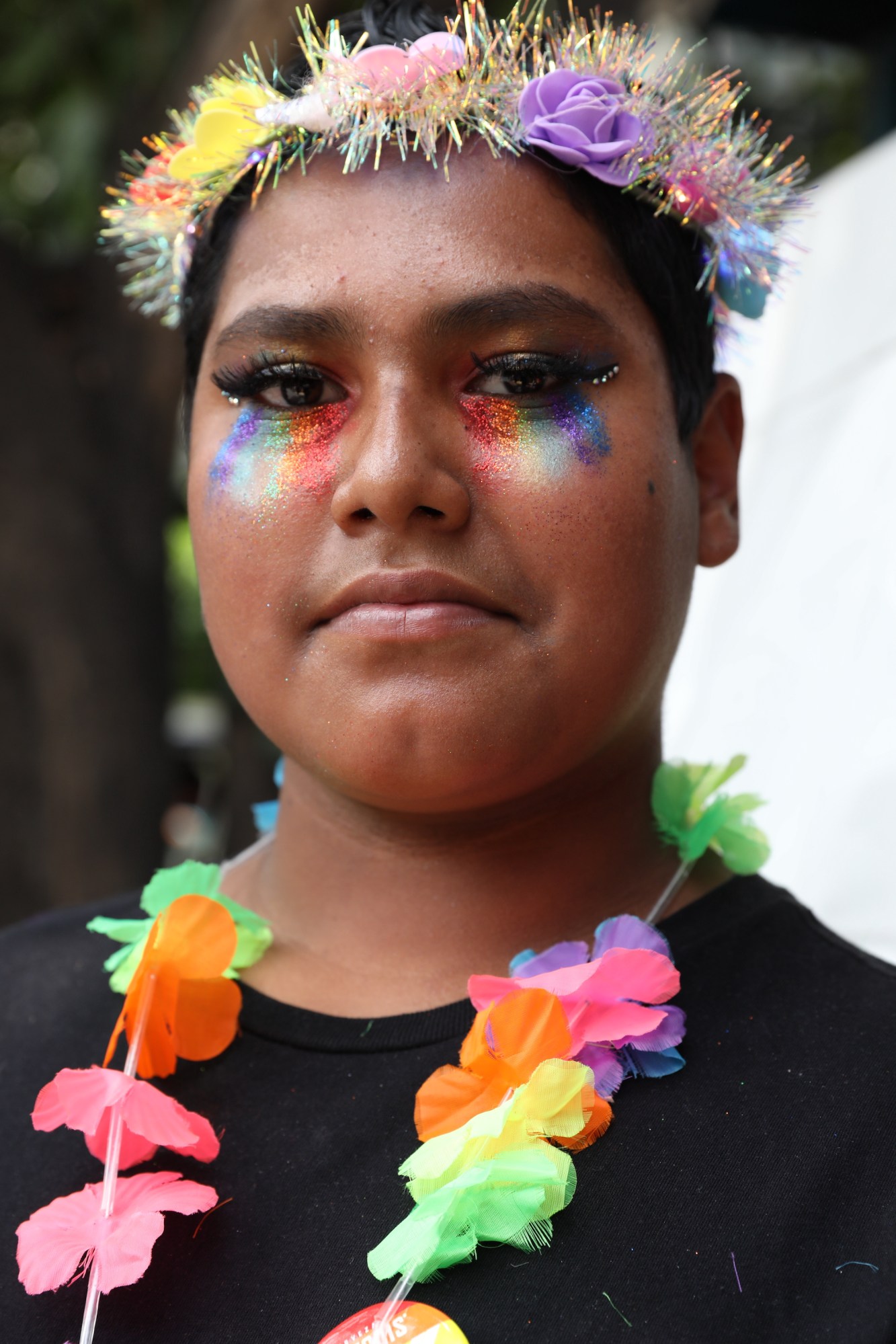 person with rainbow makeup and a garland at Mexico Pride 2022