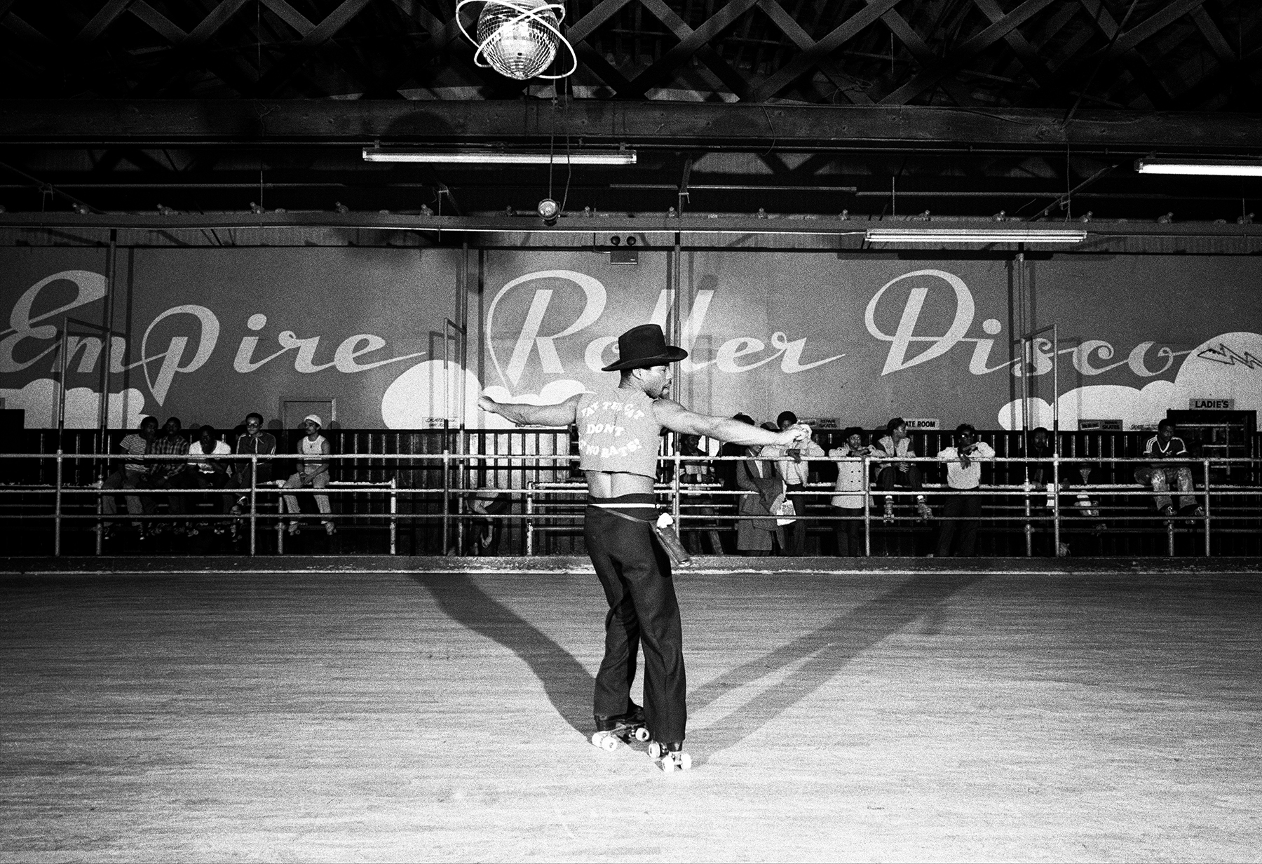 black-and-white photo of roller disco dancer in cowboy hat