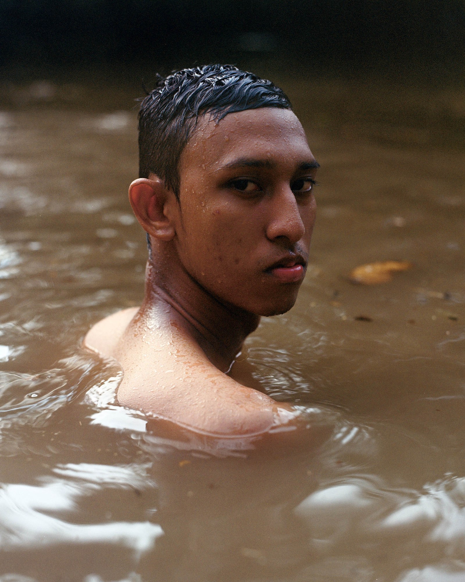 A young person swimming in the river.