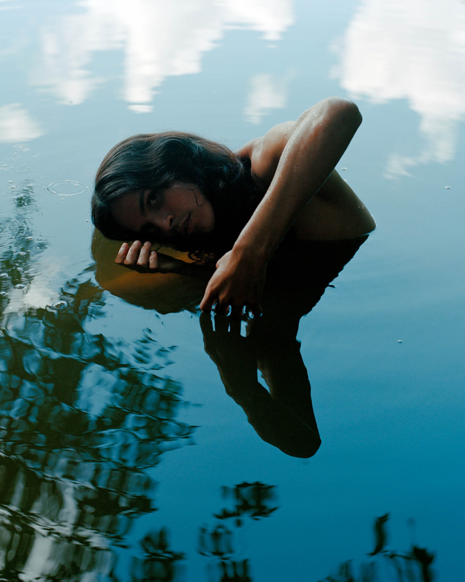 A young person posing in reflective water.