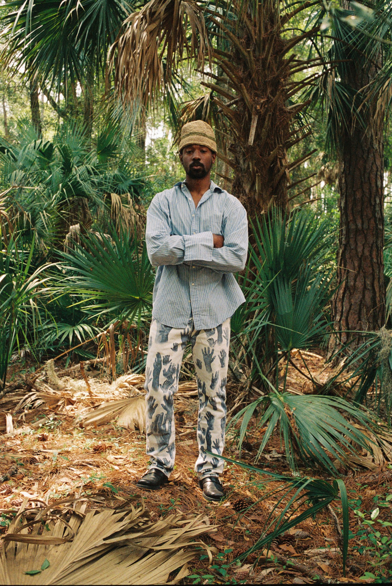 model wearing denim tears clothing in the forest