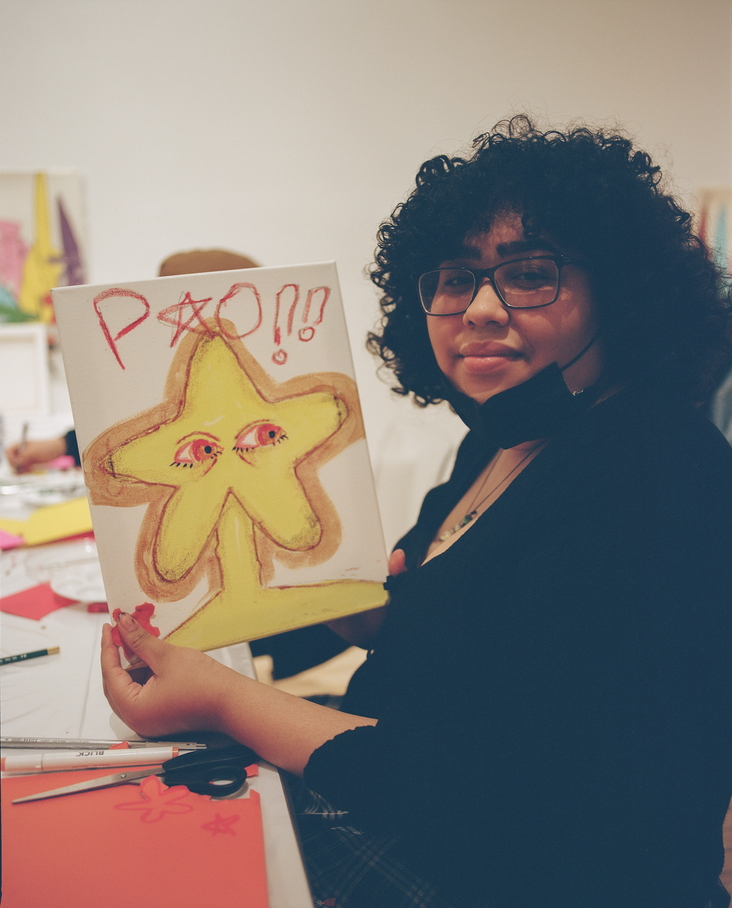 Paola holding a piece of her artwork.