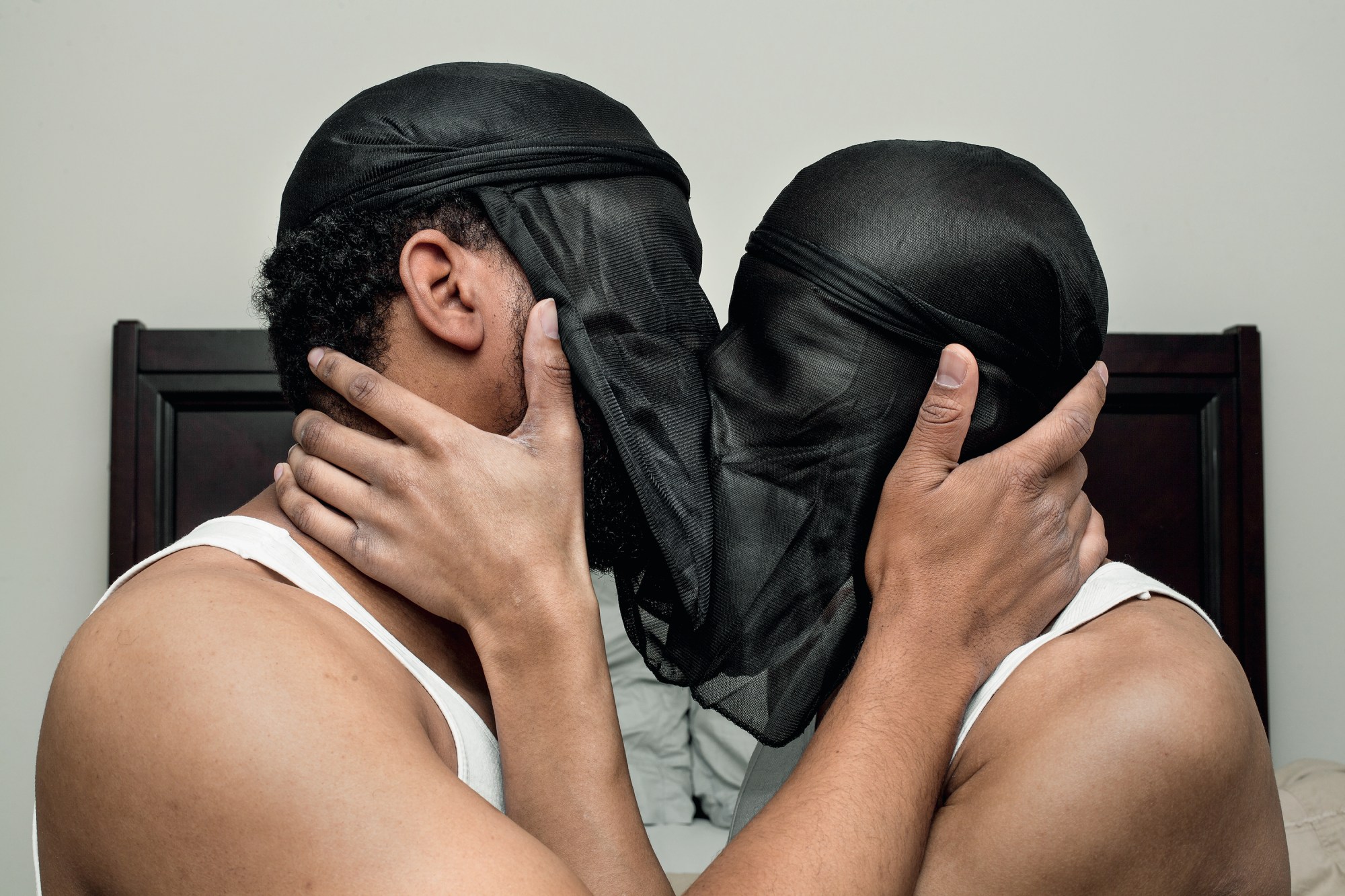 two people kiss through durags, spun round to cover their faces like veils