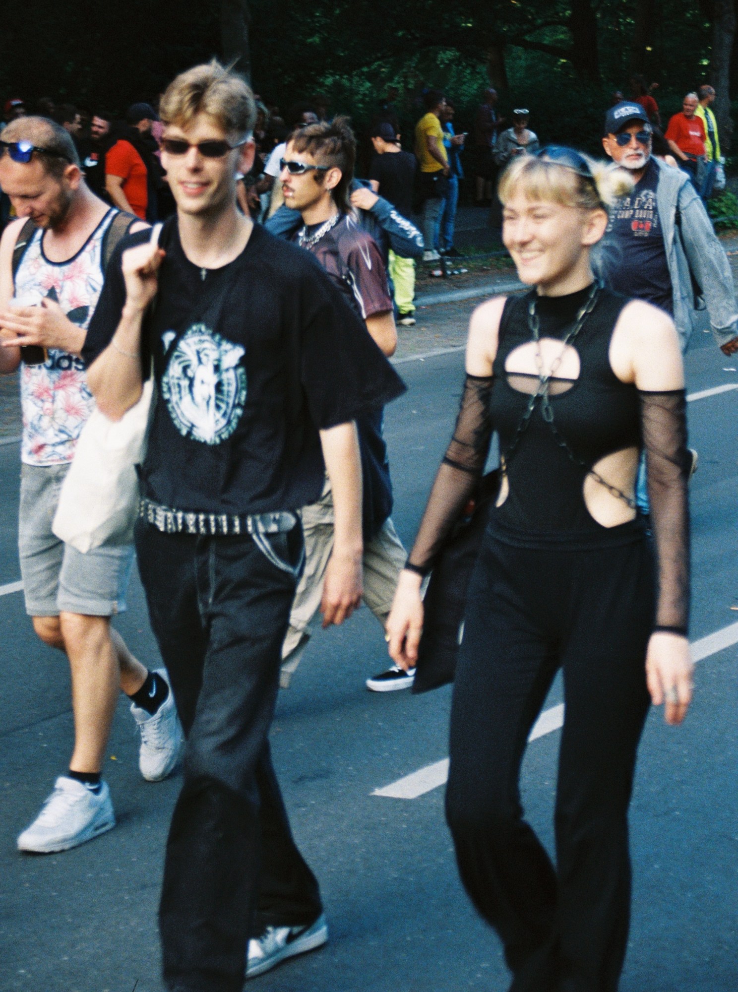 a couple wearing 90s goth looks walk down the street