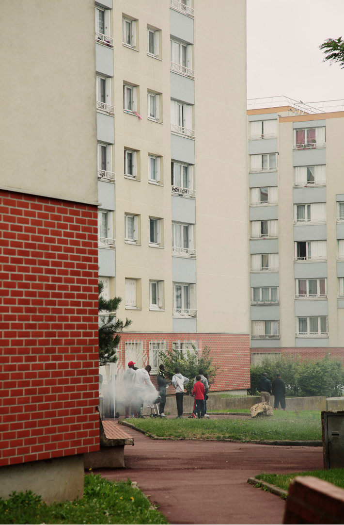 people having a barbecue outside a paris tower block