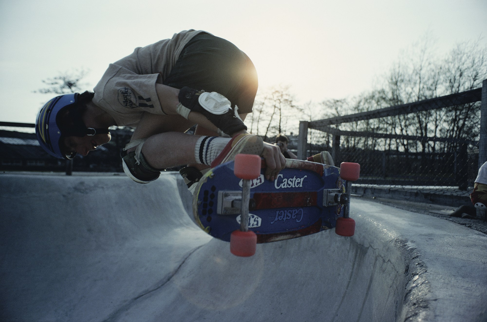 Photo of Nick Waplington in the air skateboarding on a rink outside