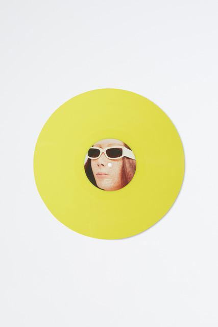 a collage of a woman's face wearing sunglasses, surrounded by a yellow circle on a white page