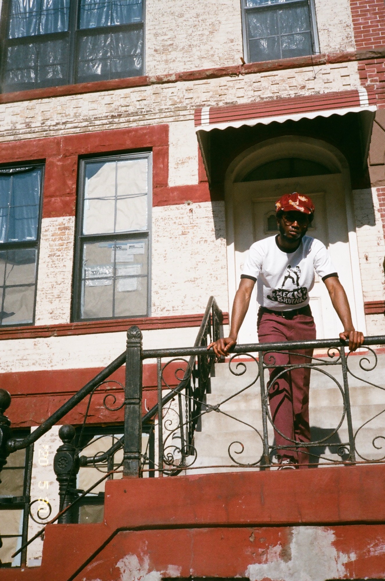 A man standing on red steps in Crown Heights Brooklyn