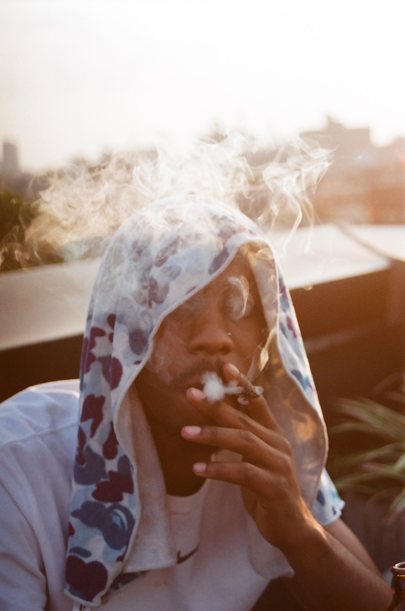 Man smoking in front of an orange sunset