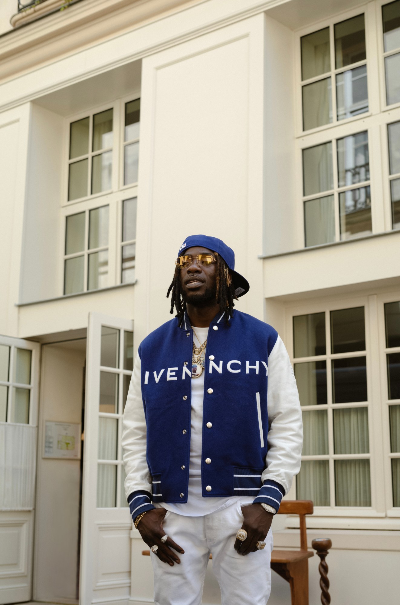 gazo poses in a blue givenchy varsity jacket