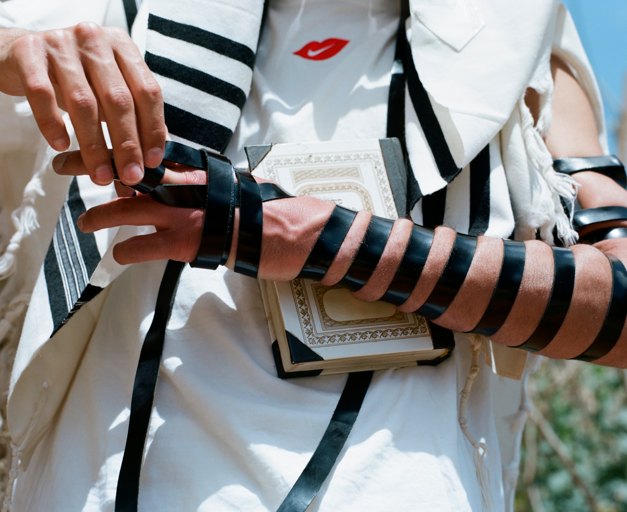 A young Orthodox Jewish holding a reglious book.