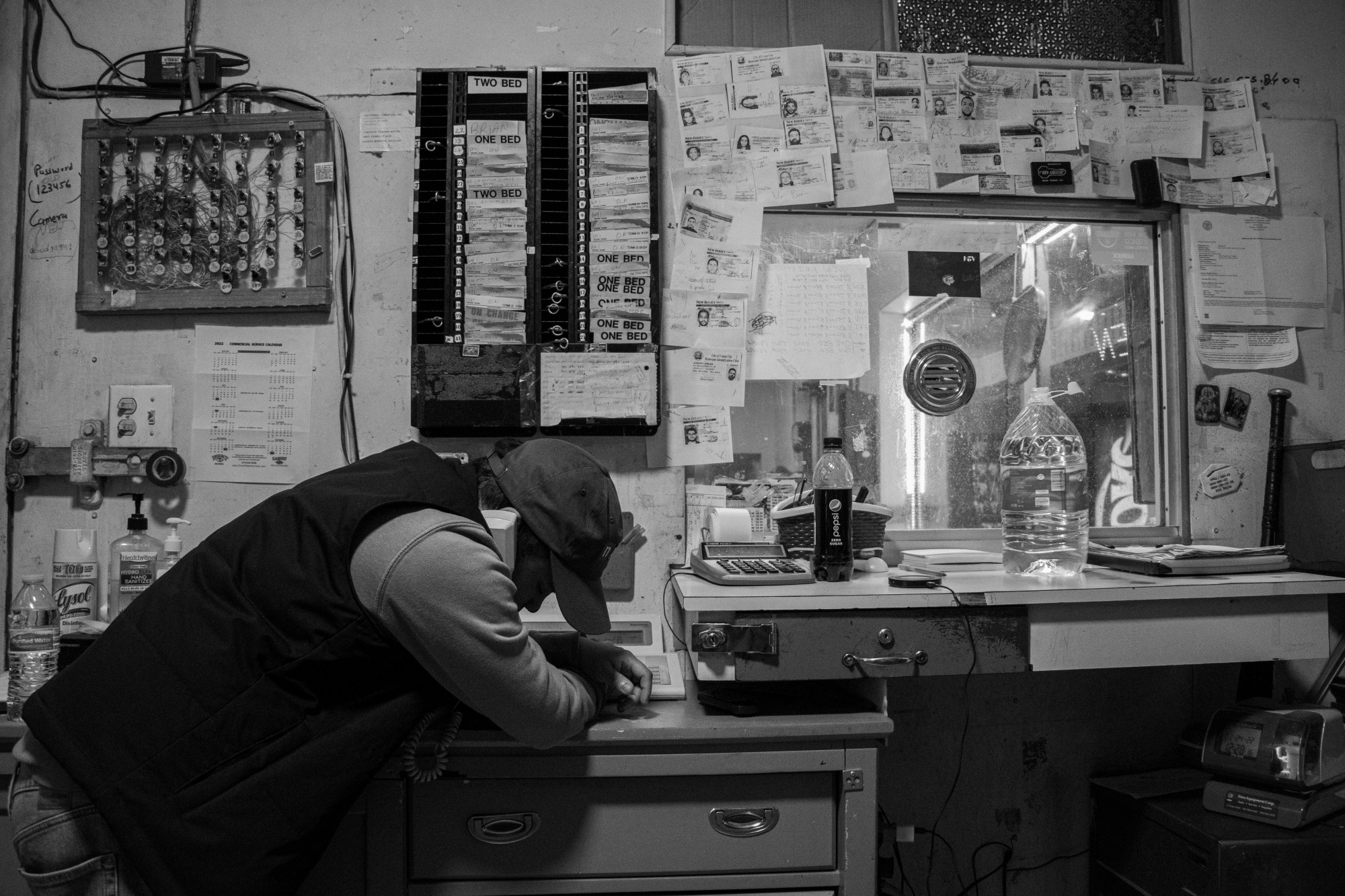 A man standing at the front desk of the Lincoln Tunnel Hotel.