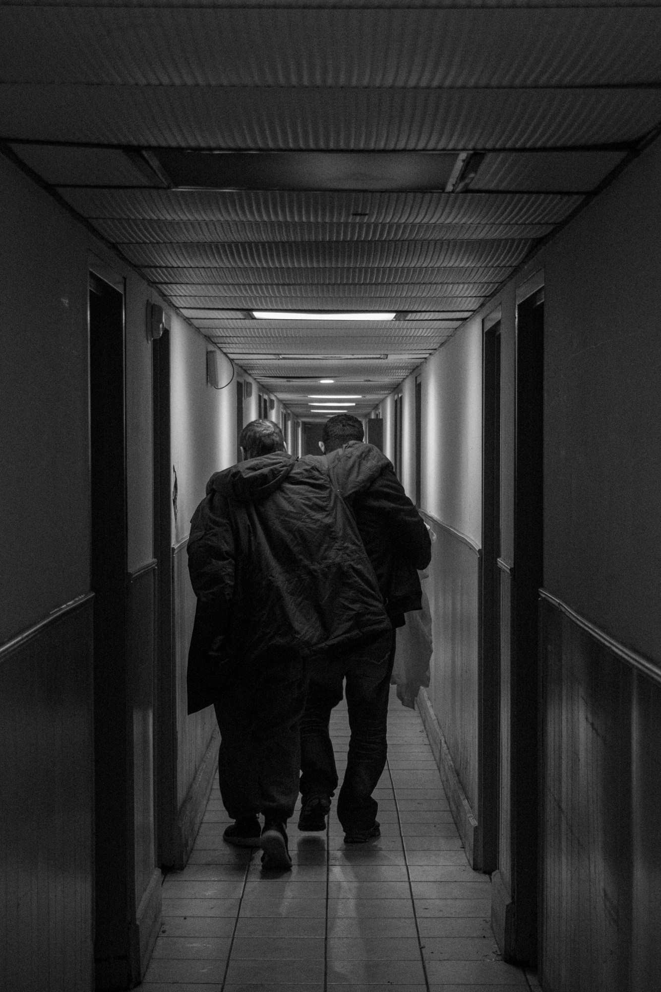 Two men walking down the hallway of the Lincoln Tunnel Hotel.