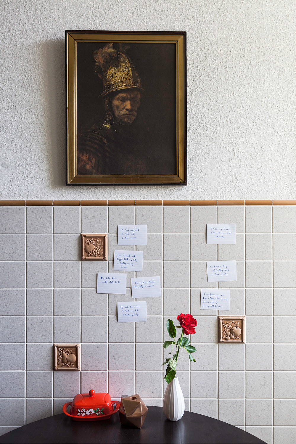 flowers on a table next to notes on a titled wall