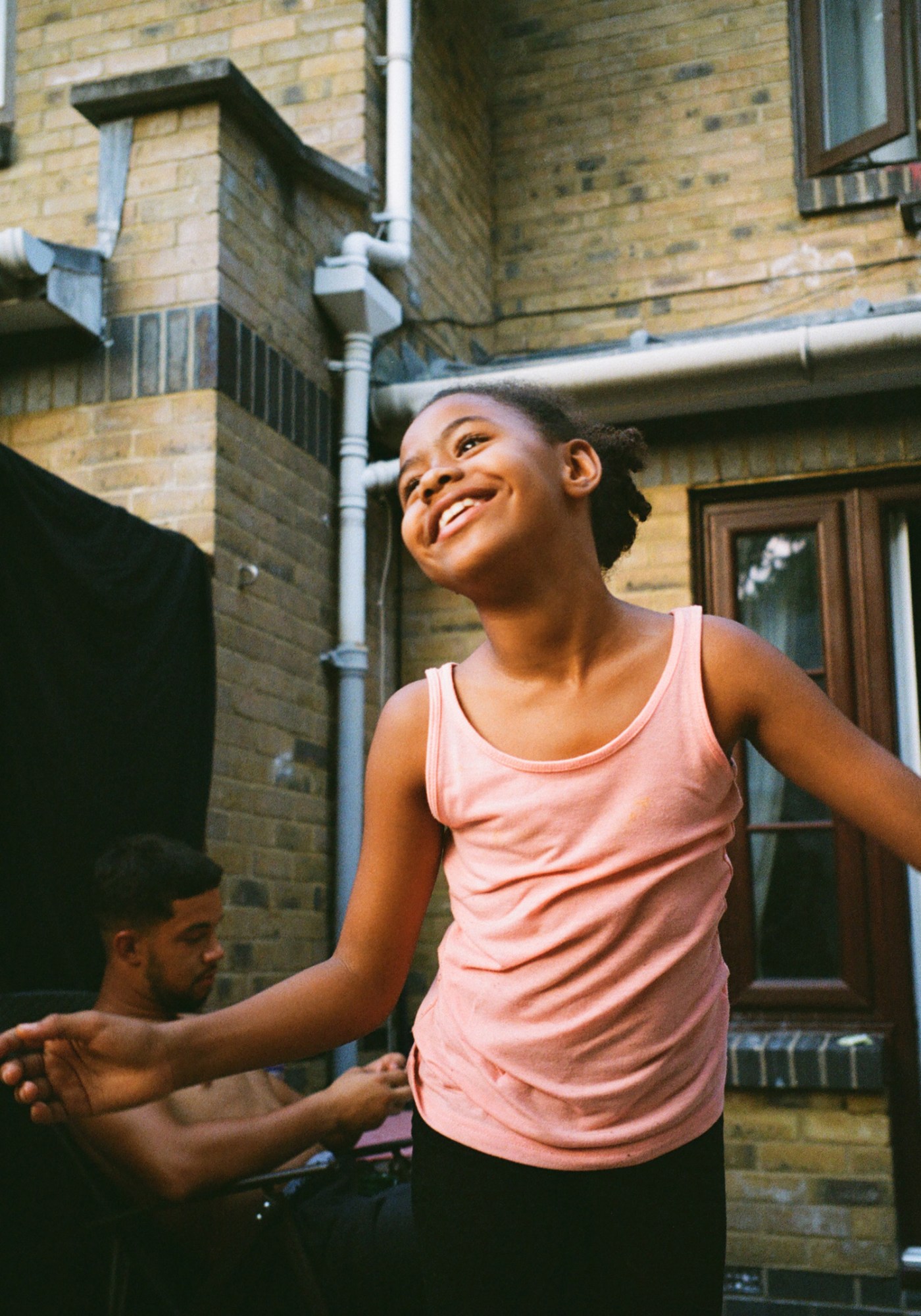 a young girl playing outside in a pink t-shirt