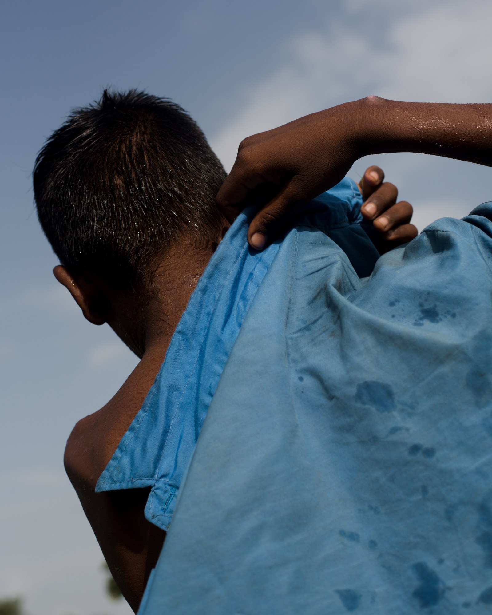 a boy pulls on a blue jacket