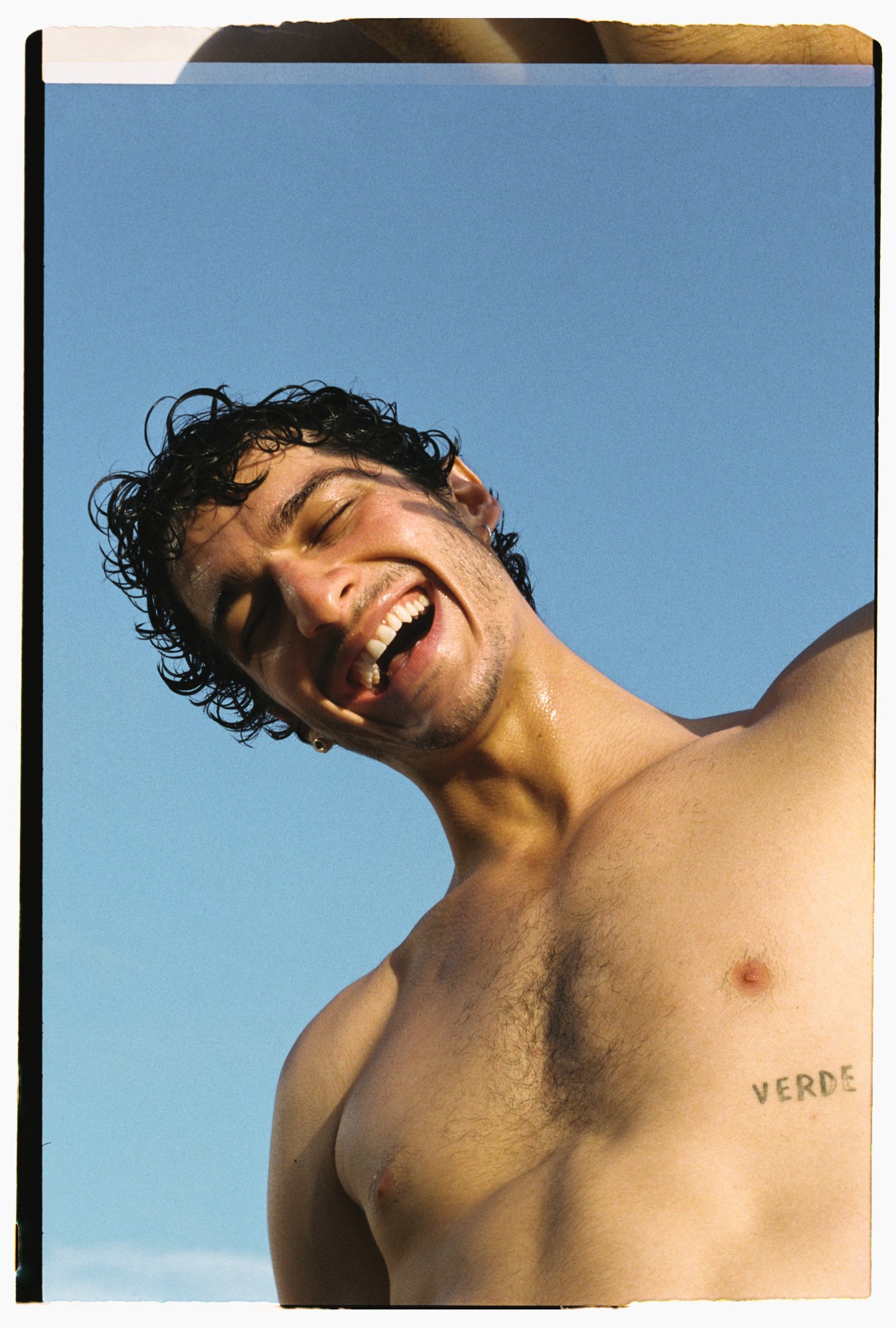 a topless man with wet hair laughing