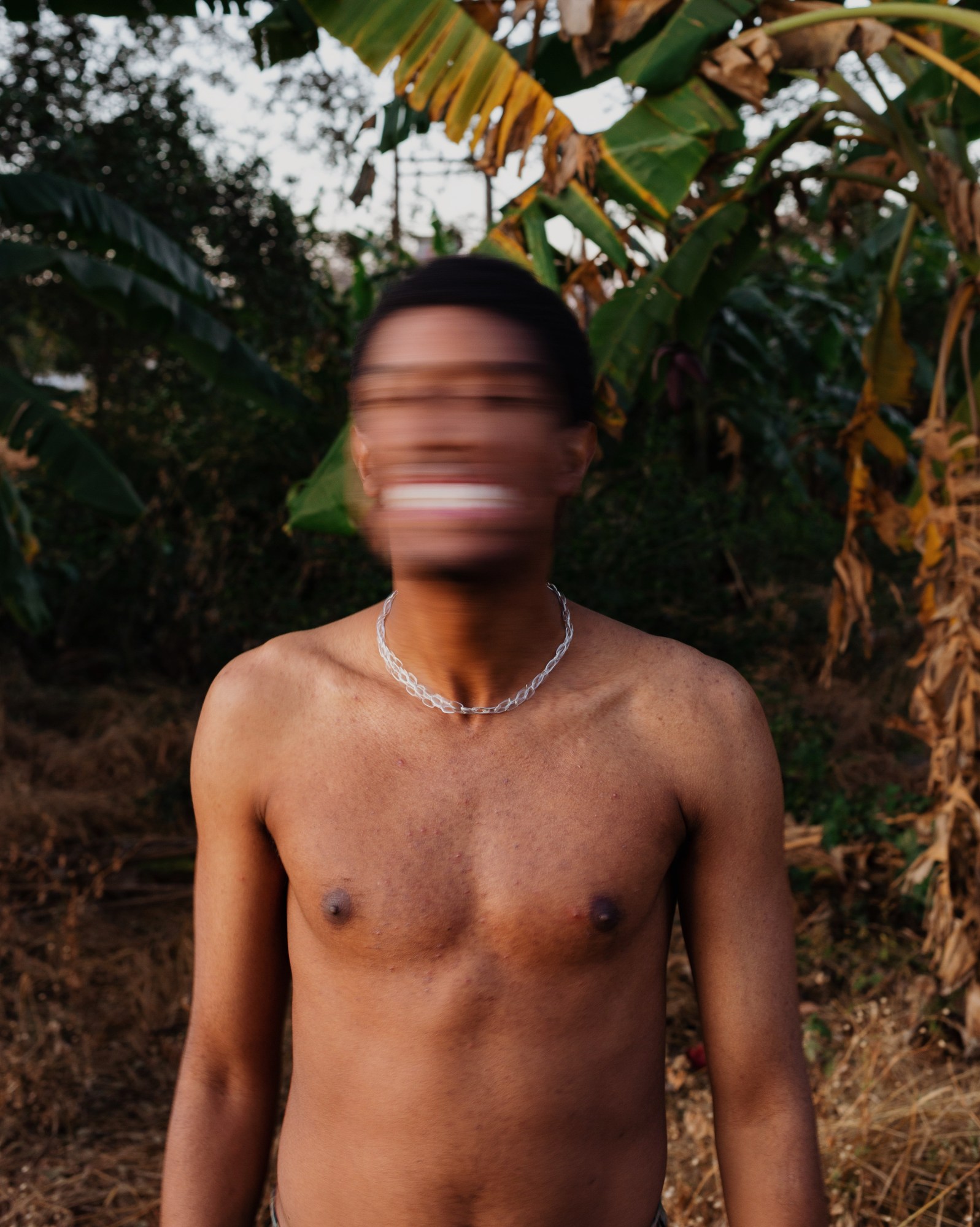 a topless man shakes his head blurring his face