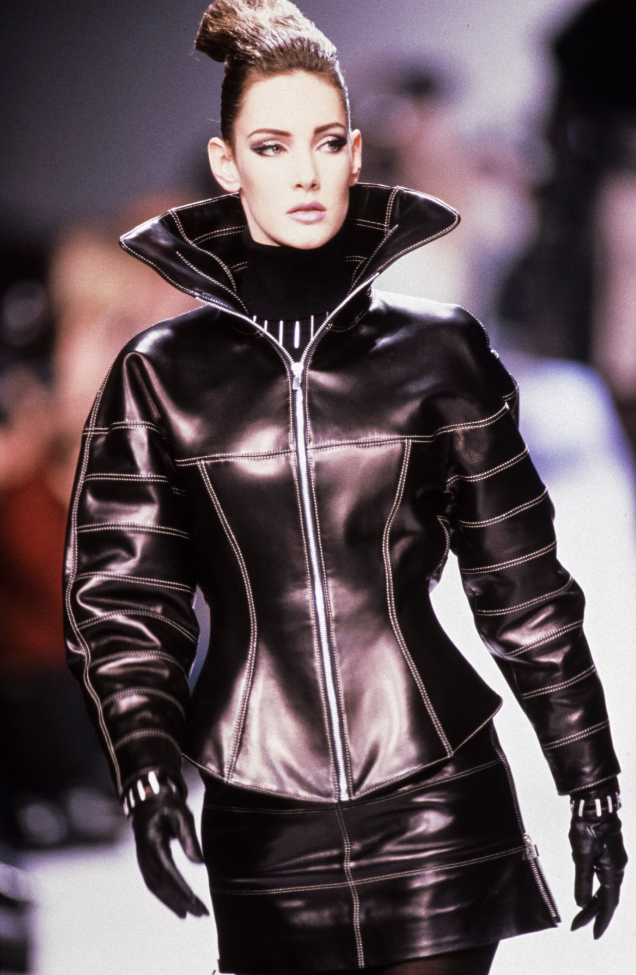 Image of a model in an all-black leather look walking Claude Montana's AW92