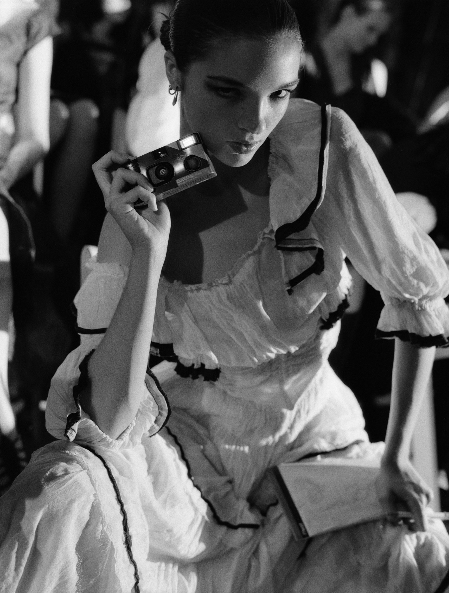 black-and-white image of model backstage with disposable camera