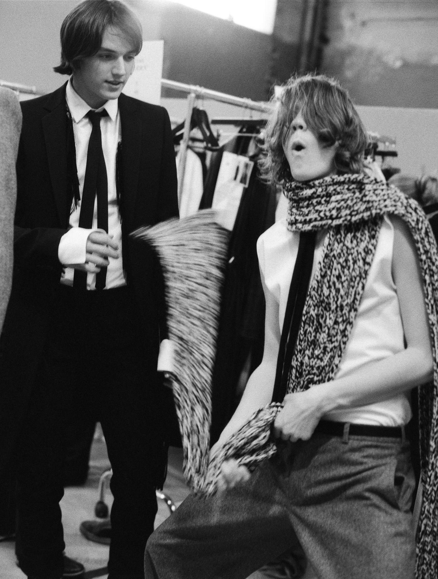 black-and-white image of male models backstage at dior