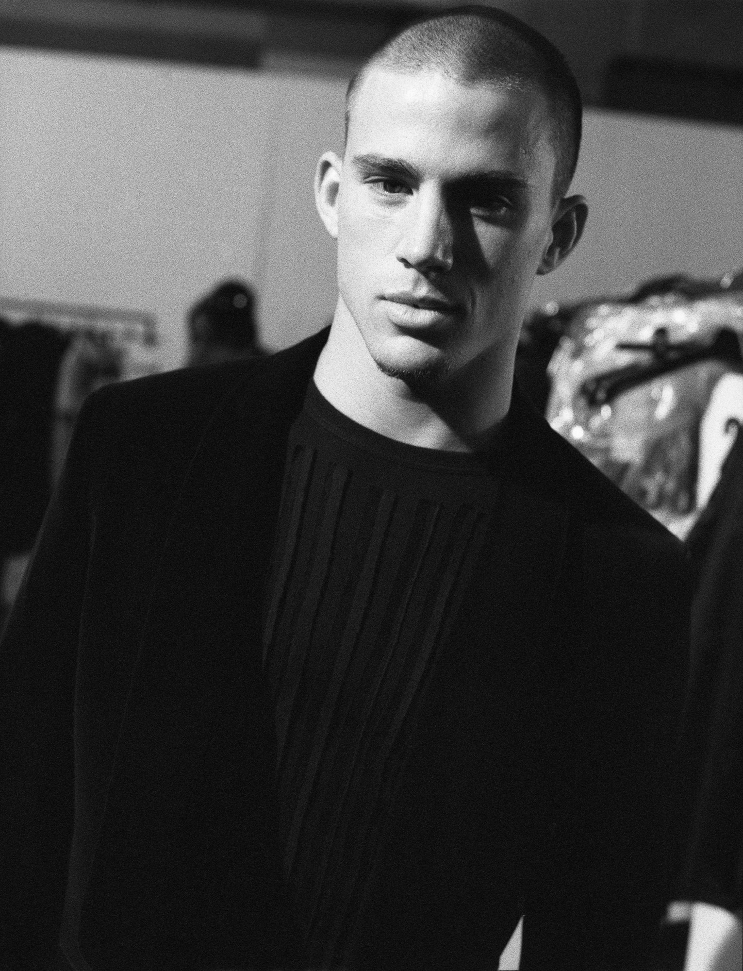 black-and-white image of channing tatum in black suit backstage at a fashion show in the 2000s