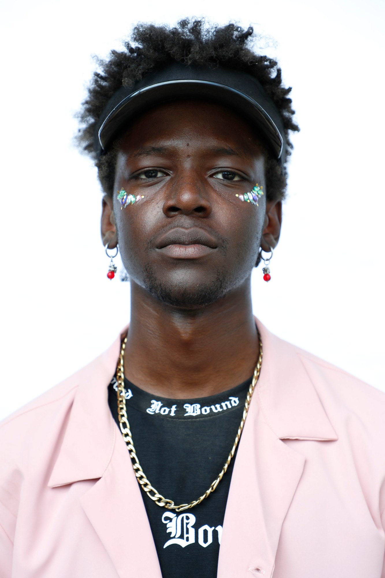 A person wearing a pink shirt and jeweled makeup