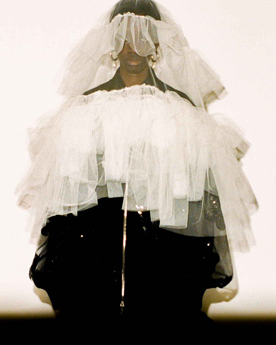 Model behind the scenes at Simone Rocha SS23 in a black dress and white veil