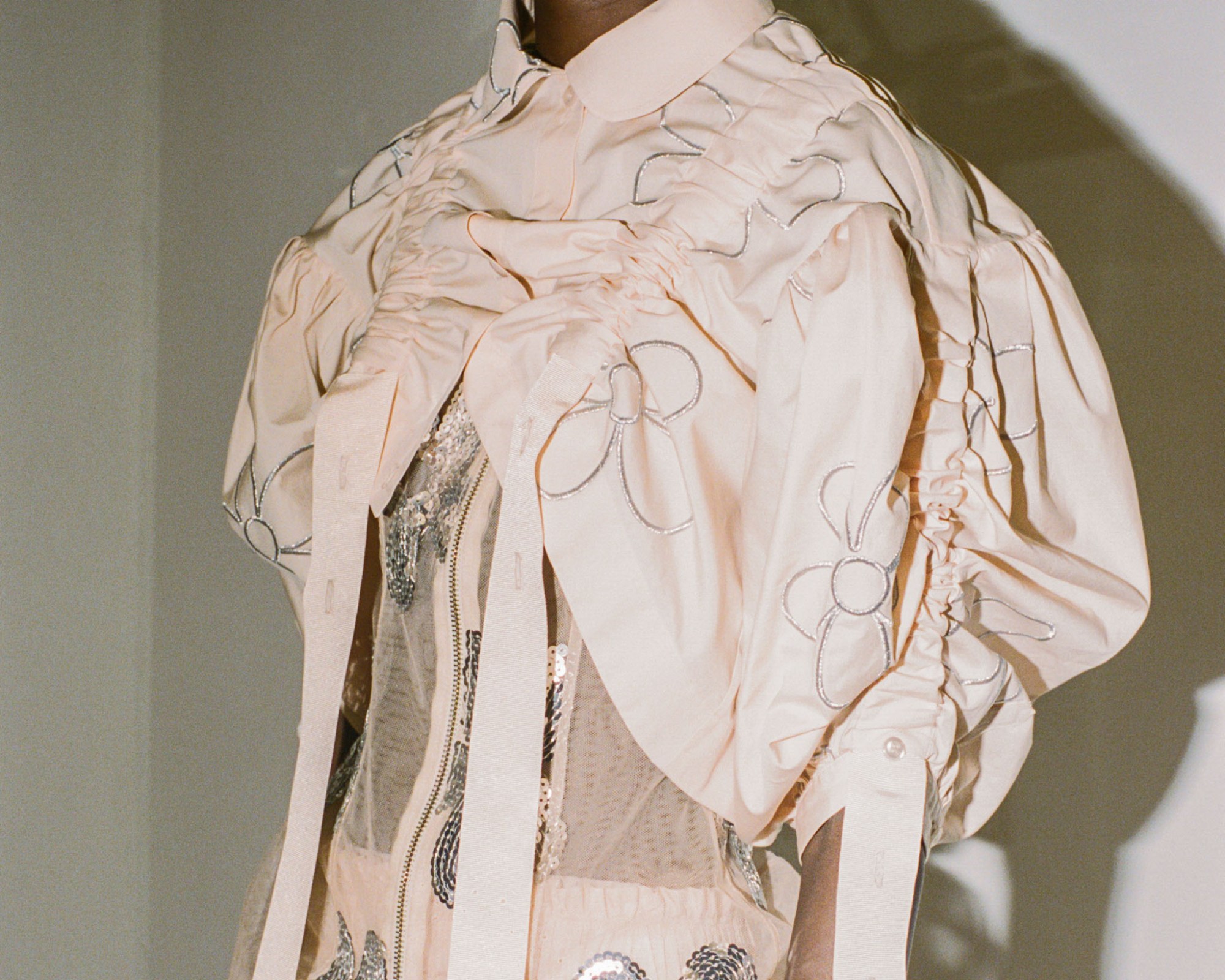 Model behind the scenes at Simone Rocha SS23 in a blush pink dress and jacket