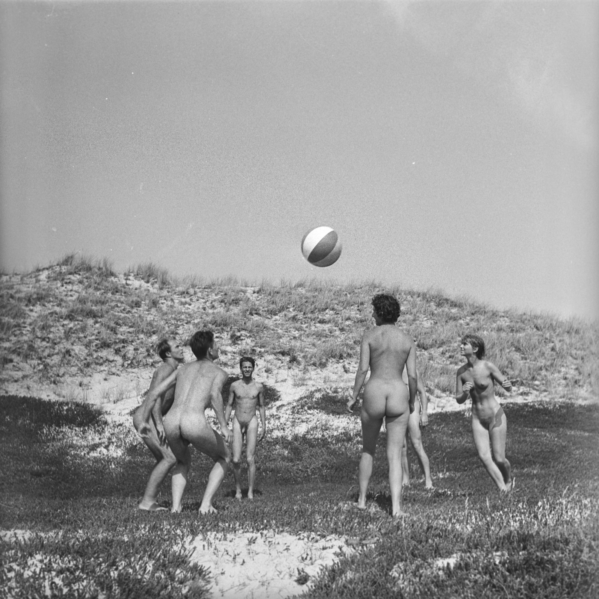 A group of nudists playing with a beach ball on the grass in the movie AROUND THE WORLD WITH NOTHING ON