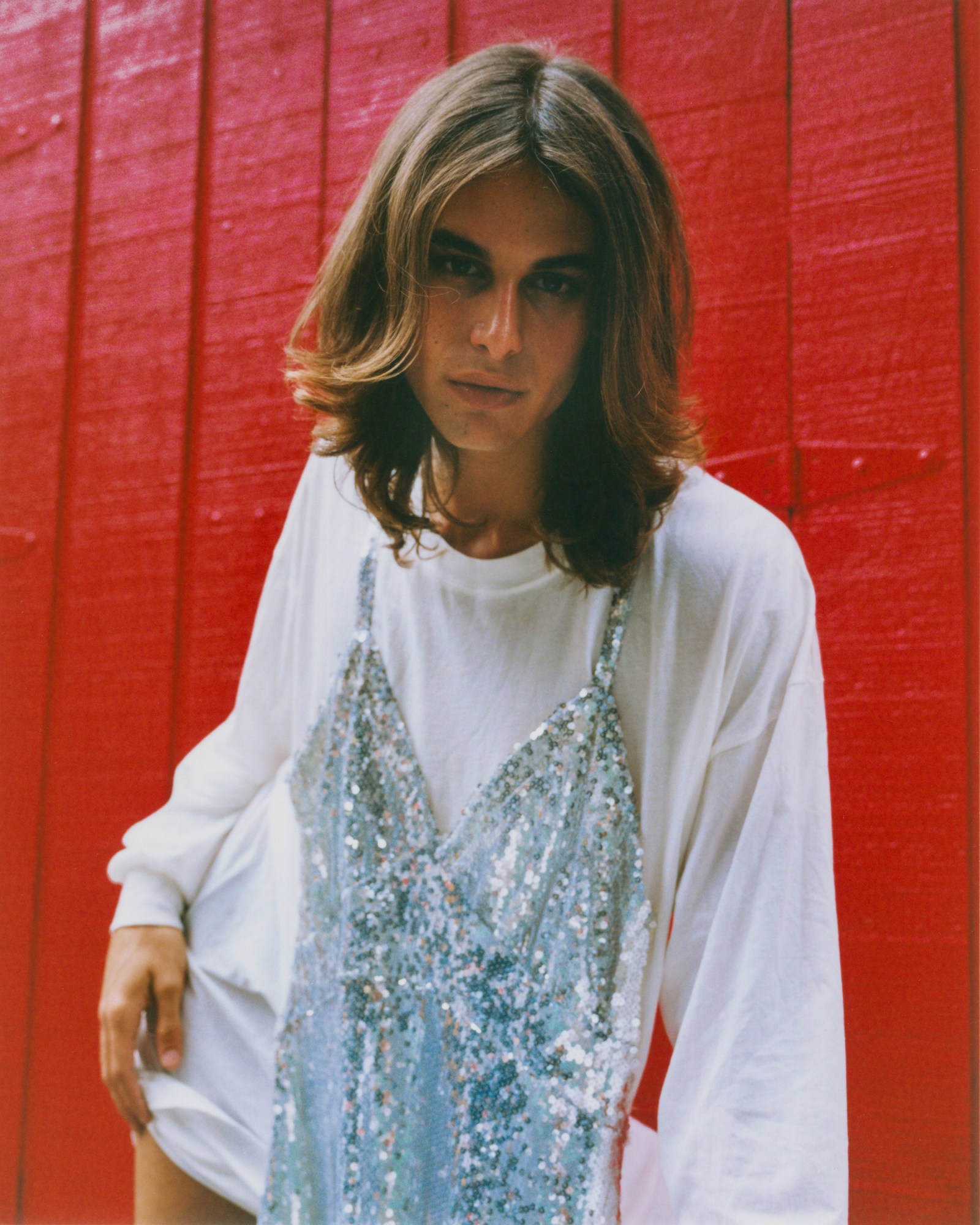 portrait of model fernando casablancas looking down at the camera in front of a red background