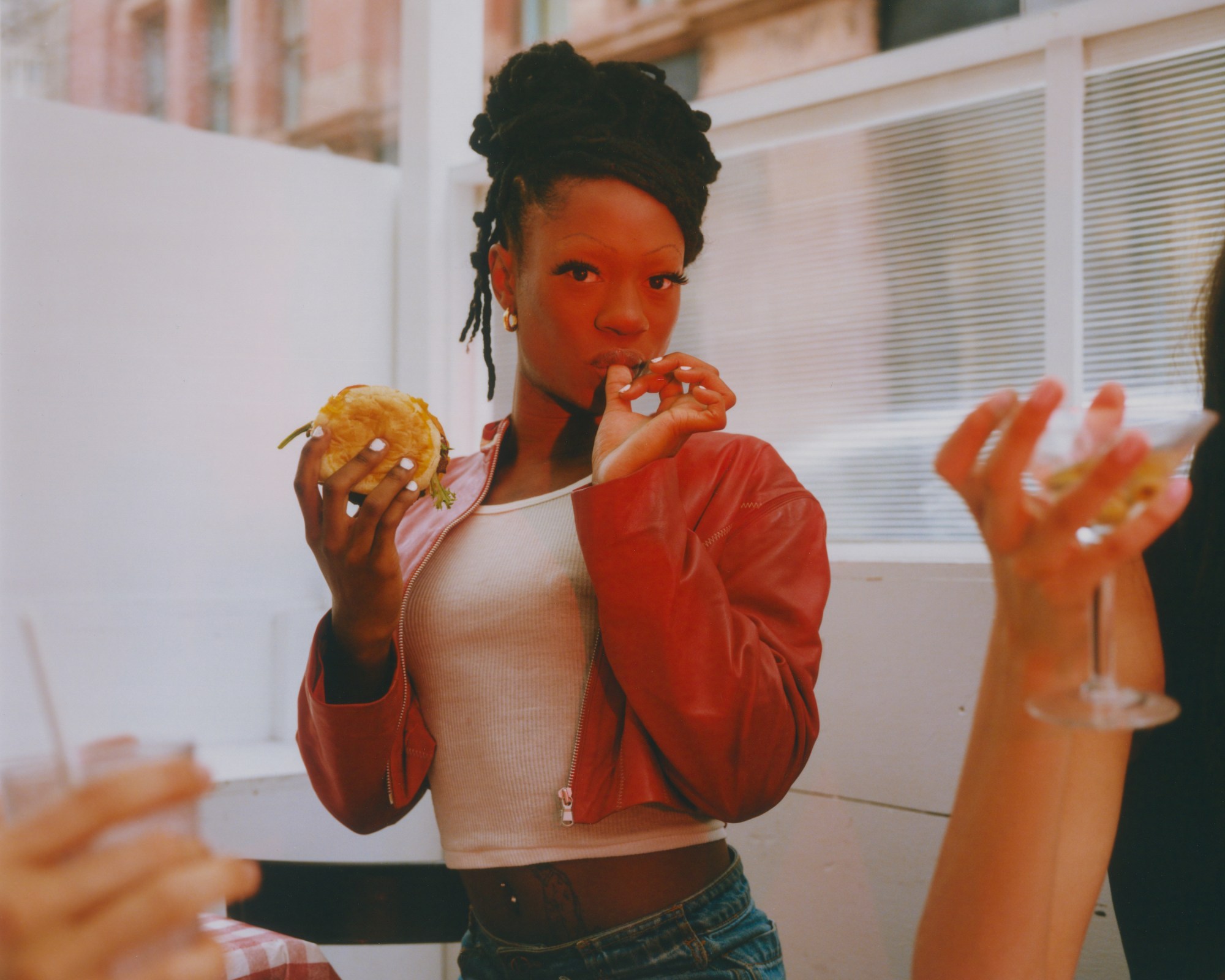 ebon gore eating a cheeseburger and licking her finger at fanelli's cafe