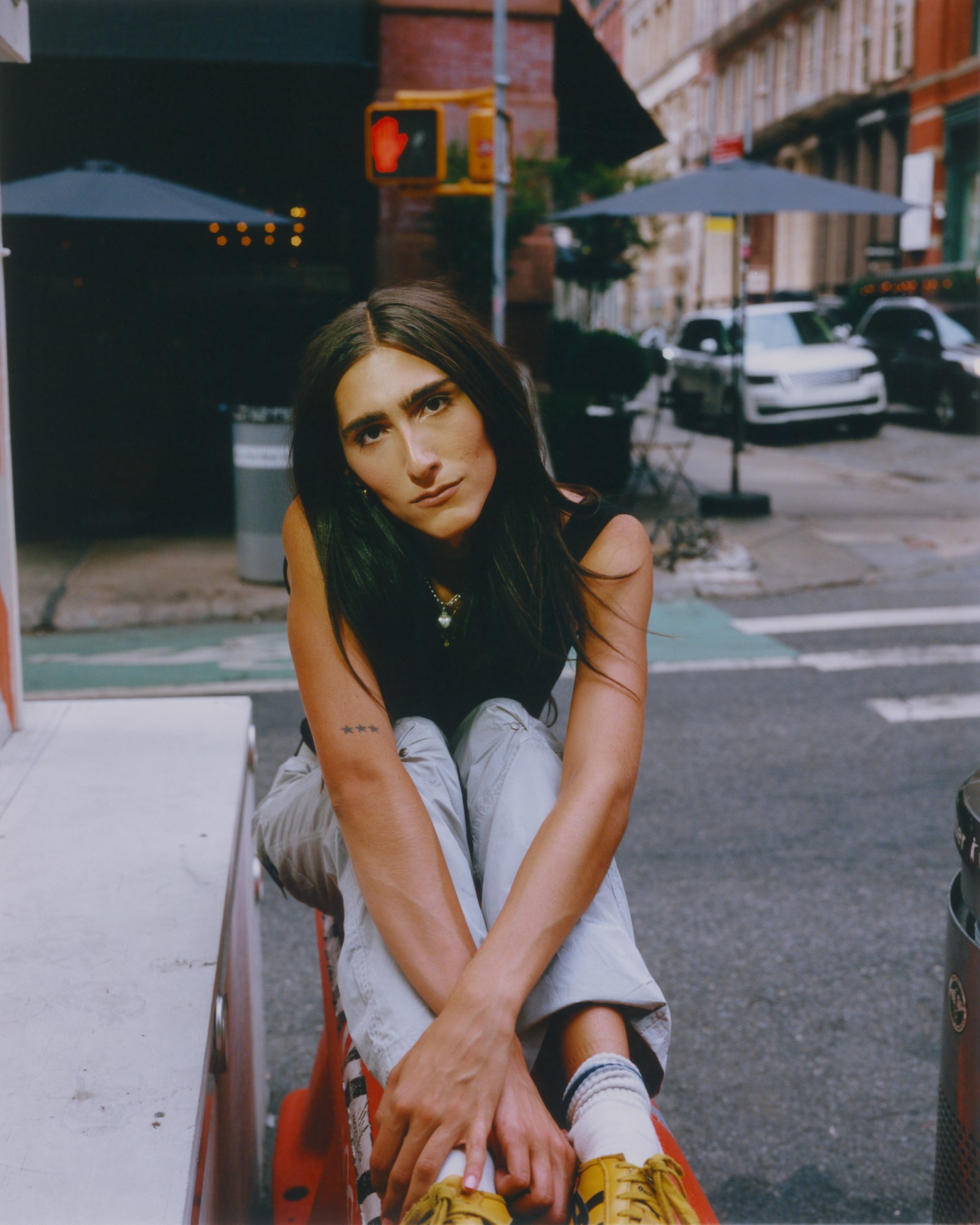 claude shwartz posing with her arms crossed on a barricade in a new york city street