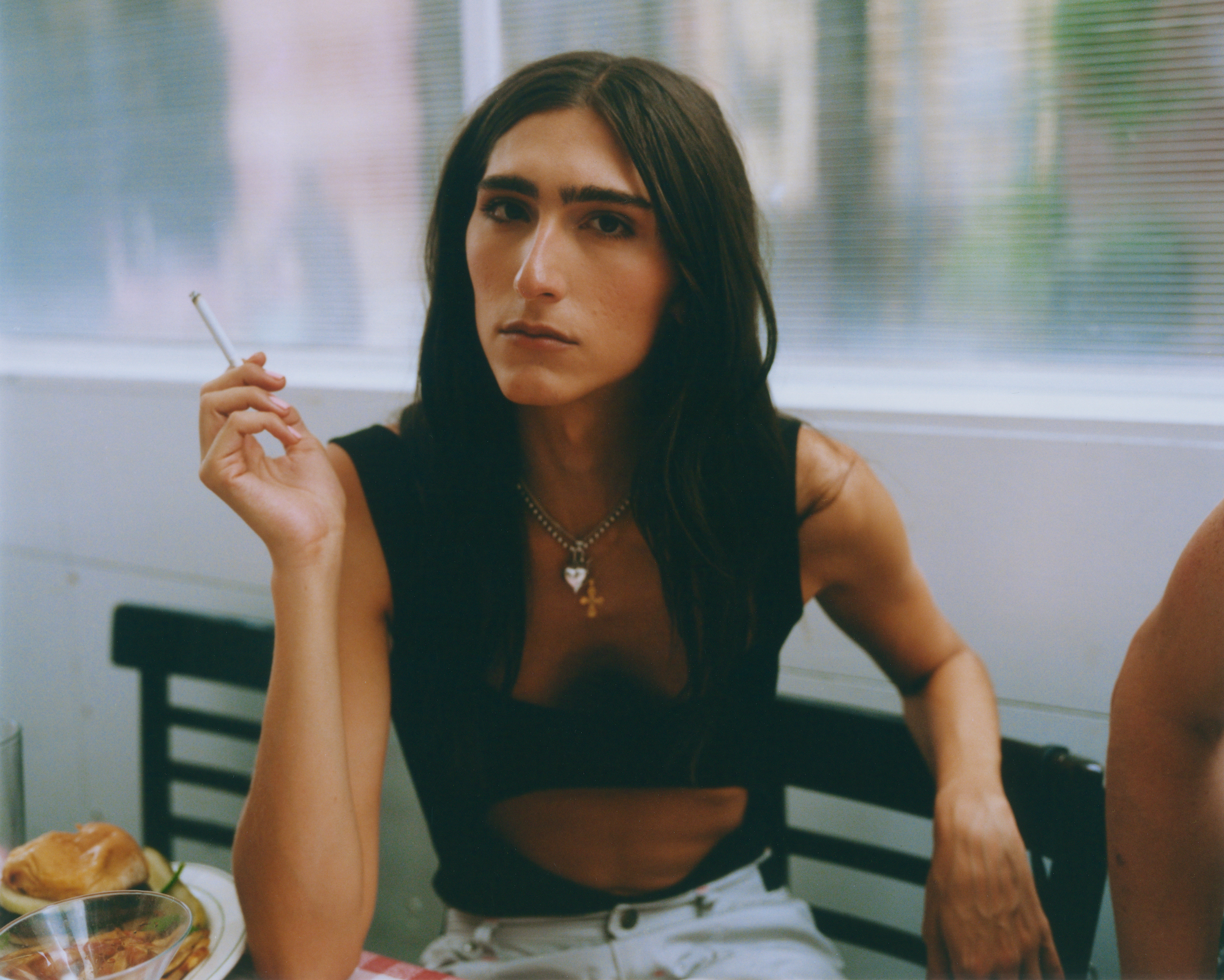 actress claude shwartz sitting at a table at fanelli's smoking a cigarette