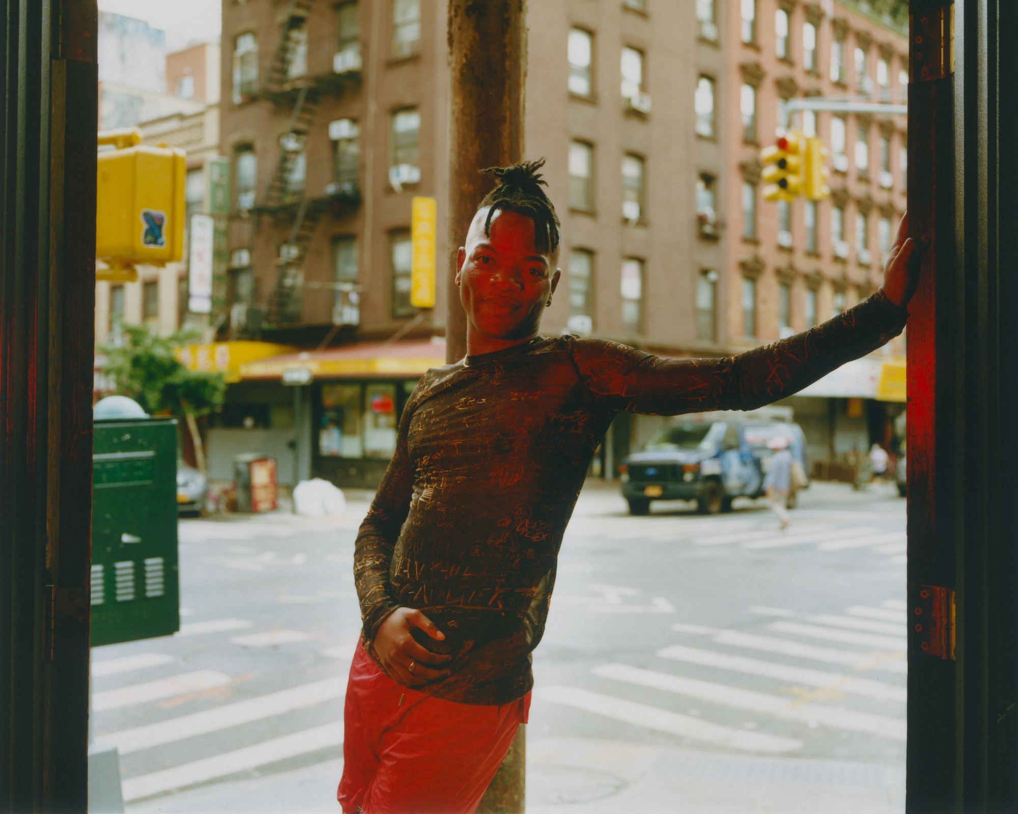 taofeek abijako standing in a doorway in front of a new york city street