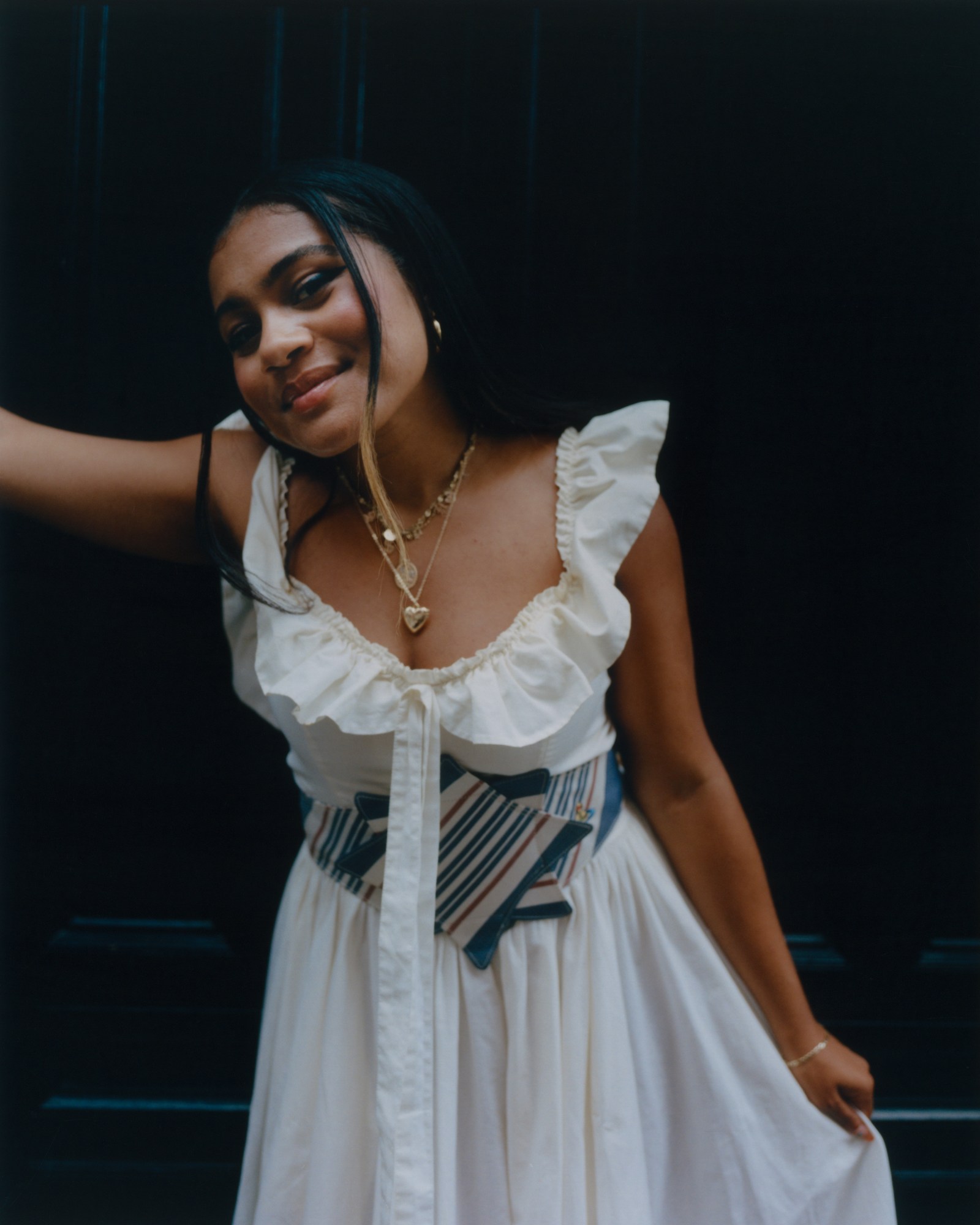 sophia wilson posing in a vintage dress in front of a black doorway