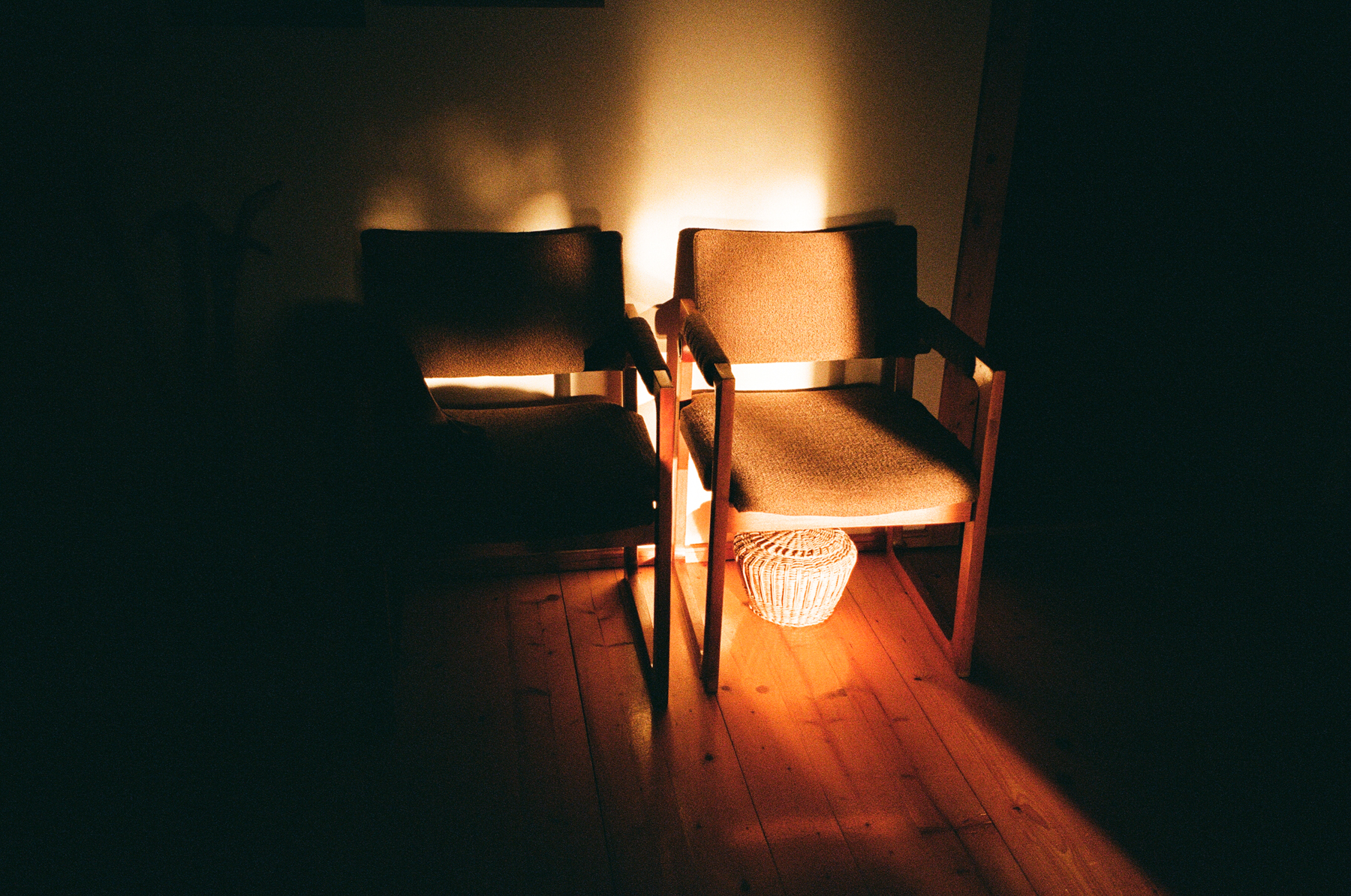 Photograph by Marie Tomanova of two empty chairs sat next to each other with a stream of light across them.