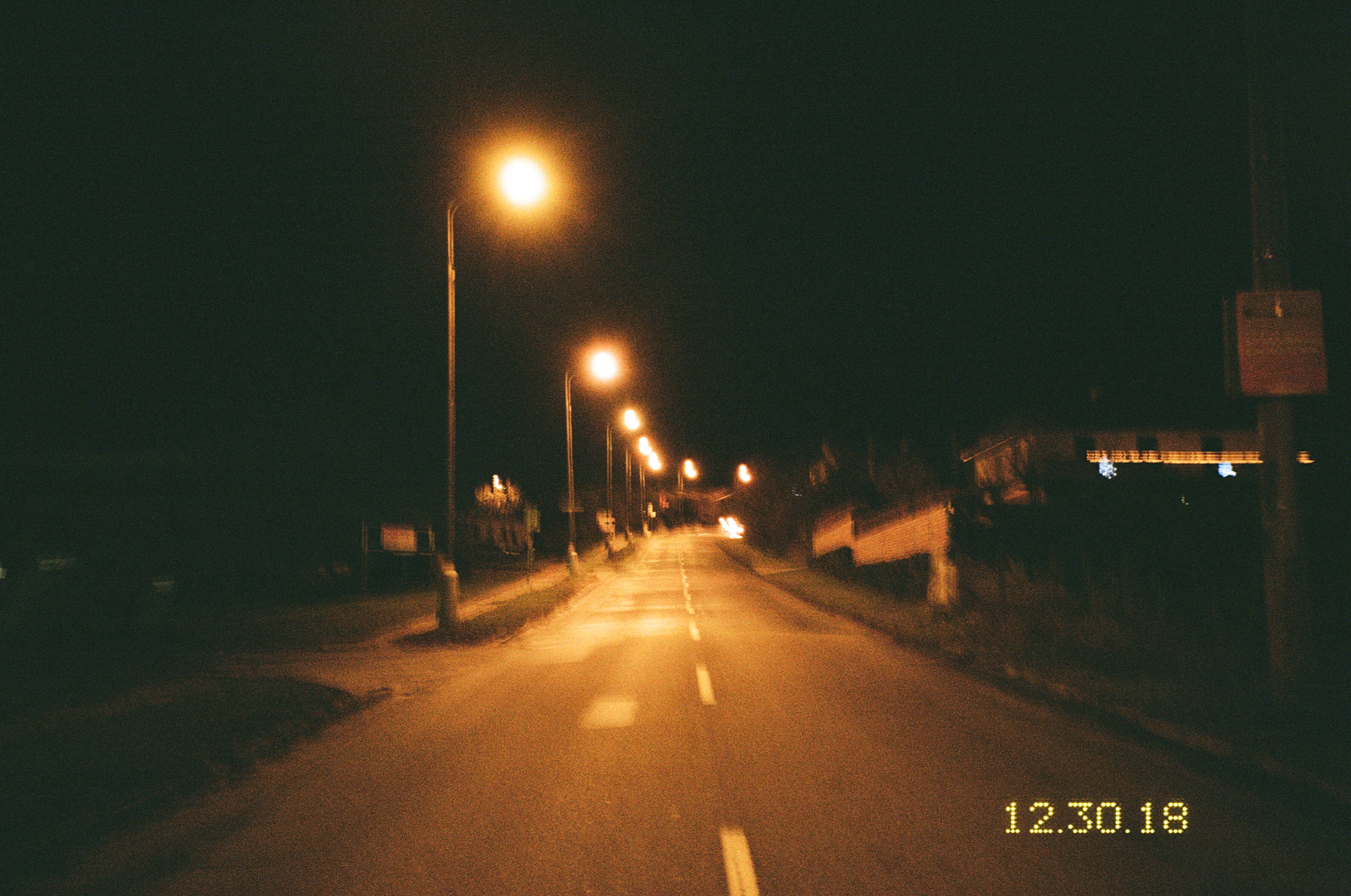 Photograph by Marie Tomanova of a street at night lit by streetlights.