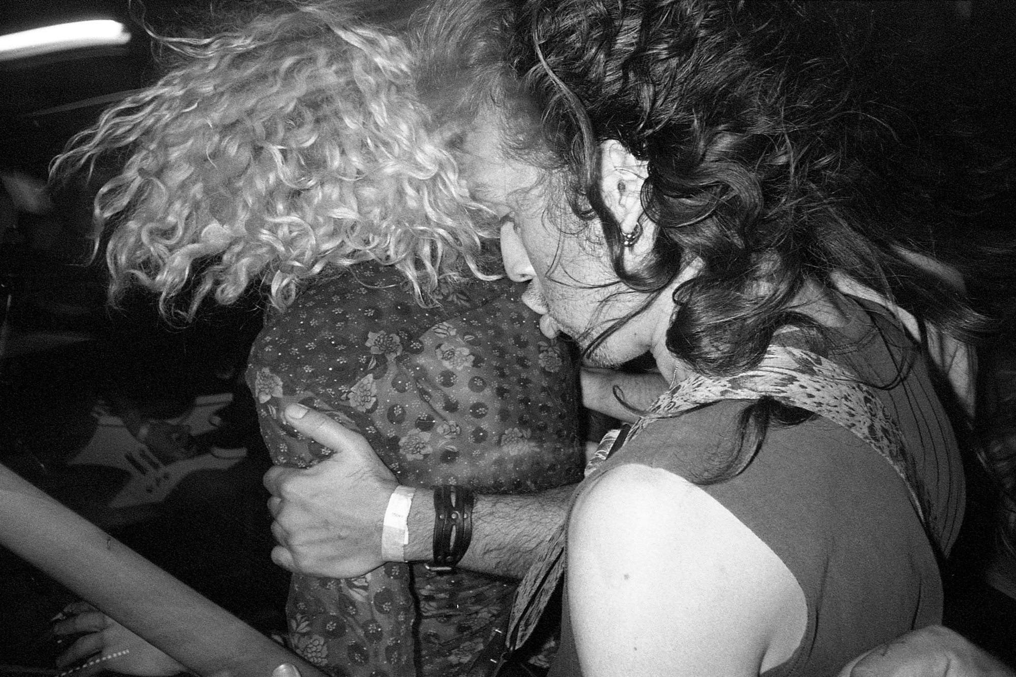 Black-and-white photograph of two club goers dancing close to each other.