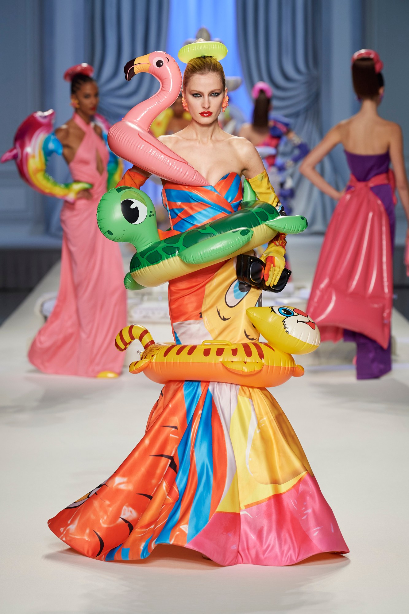 a model walks for moschino ss23 wearing an inflatable inspired multicolour ball gown