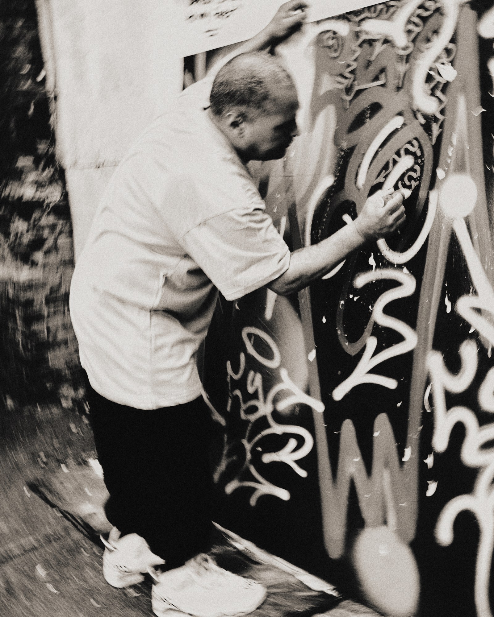 angel ortiz seen in black-and-white working on graffiti in his NYC studio