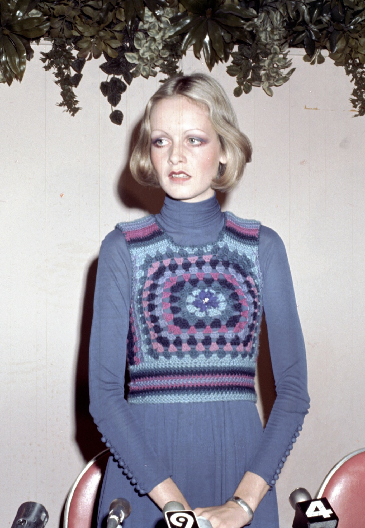 twiggy wearing a purple crochet dress standing in front of microphones at a press conference 1971