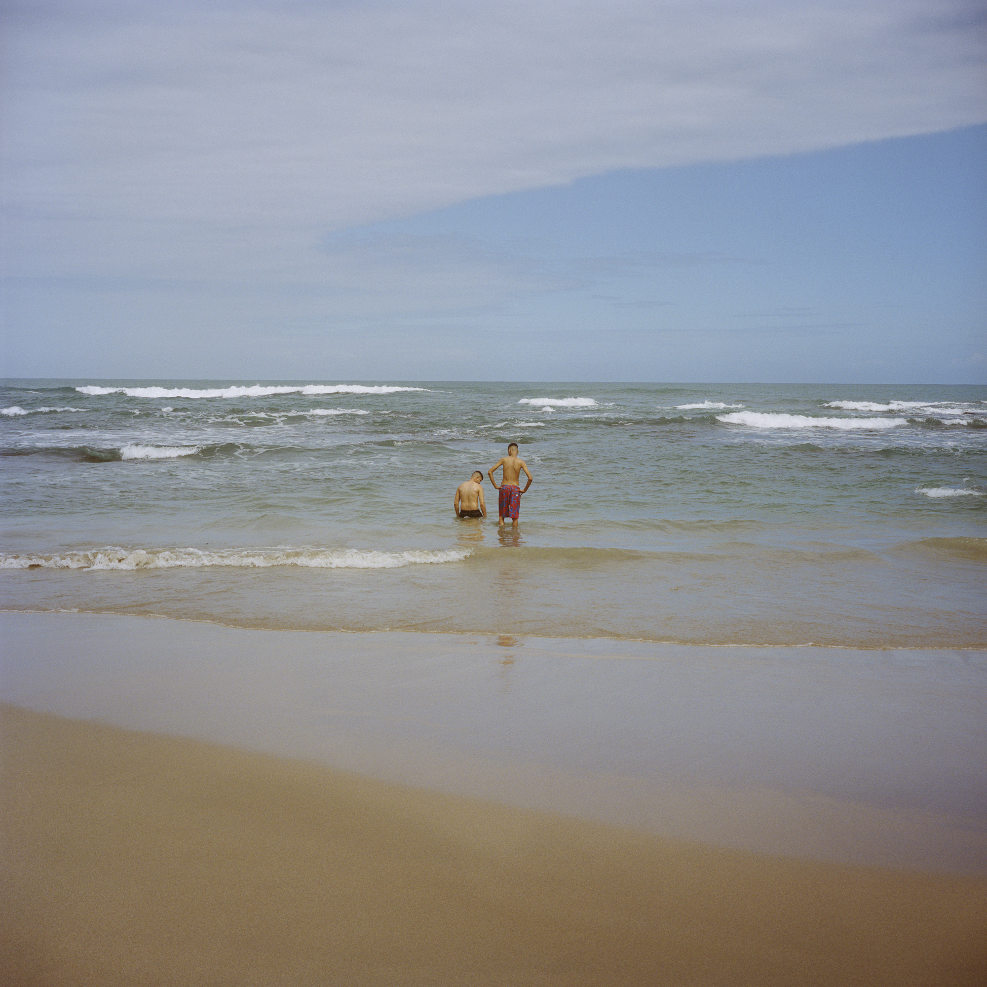 photograph by Shaniqwa Jarvis of two people in the ocean by the seaside