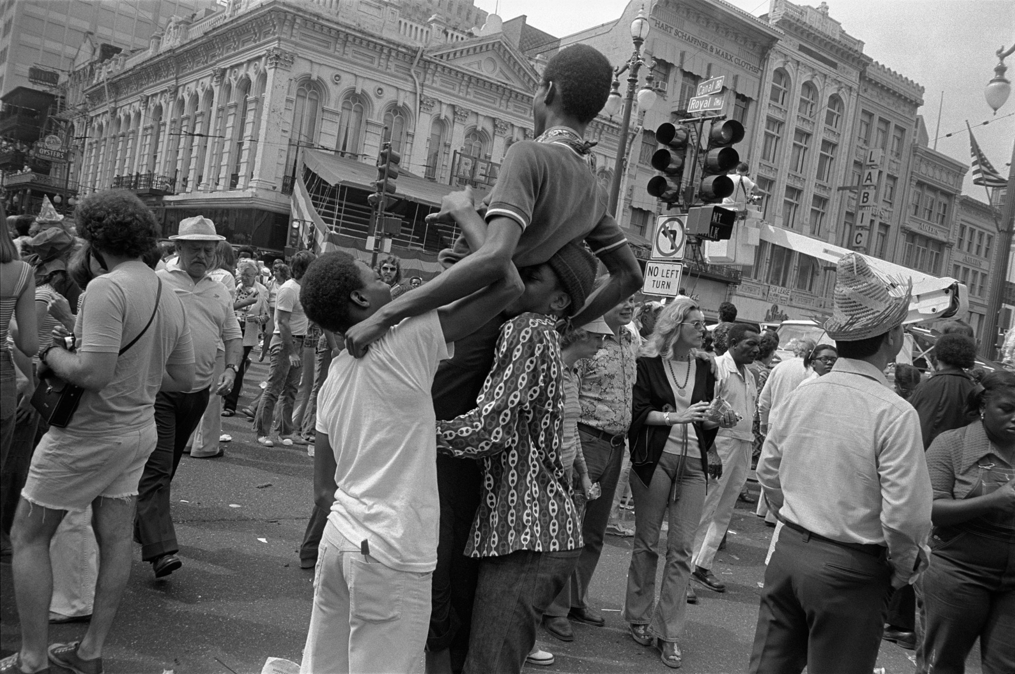 two boys lifting up their friend in a crowded street