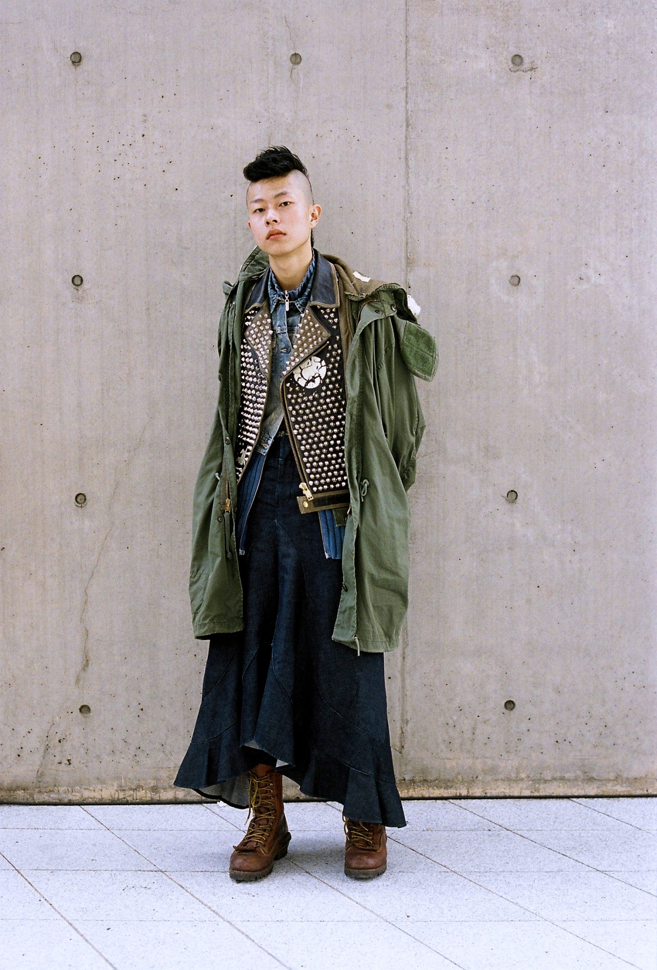 a korean person with a mohawk wears a layered punk-inspired outfit