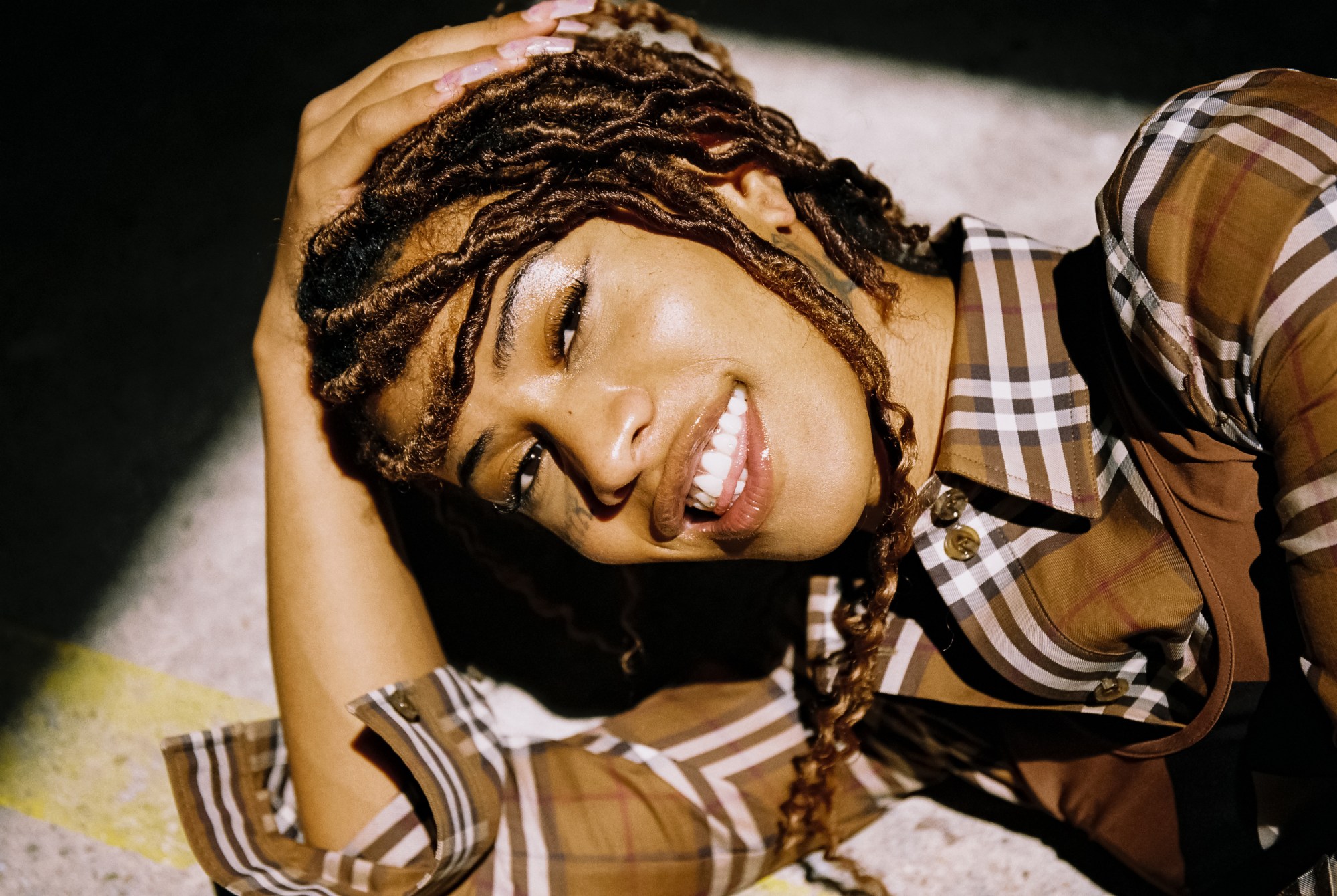 A woman lying on the floor, grinning at the camera