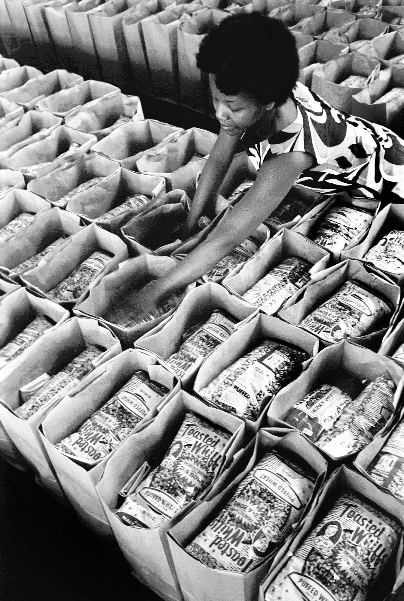 black-and-white photo of a women of the black panther party packing food bags