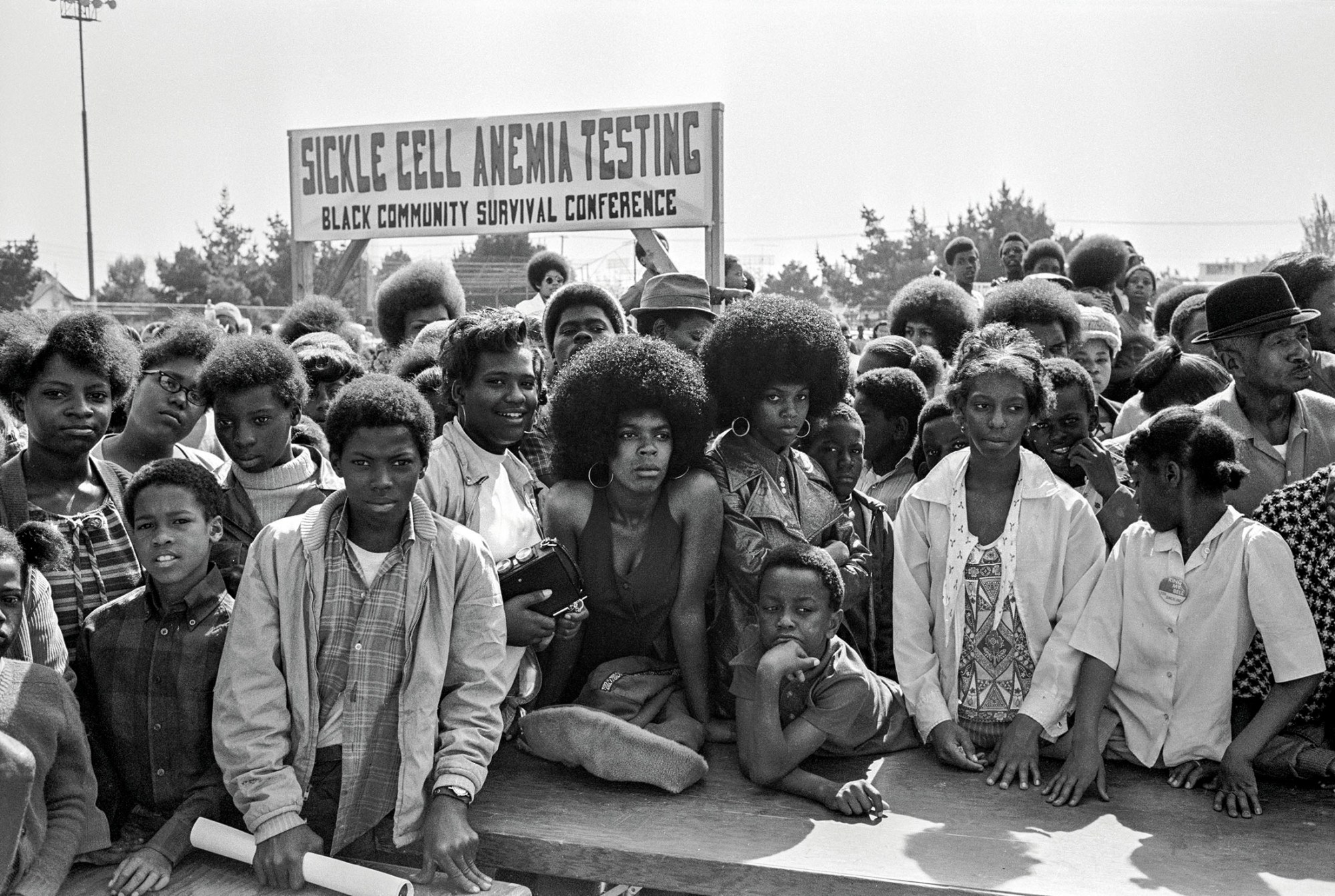 black-and-white photo of a group of young people at a sickle cell anaemia testing black community survival conference