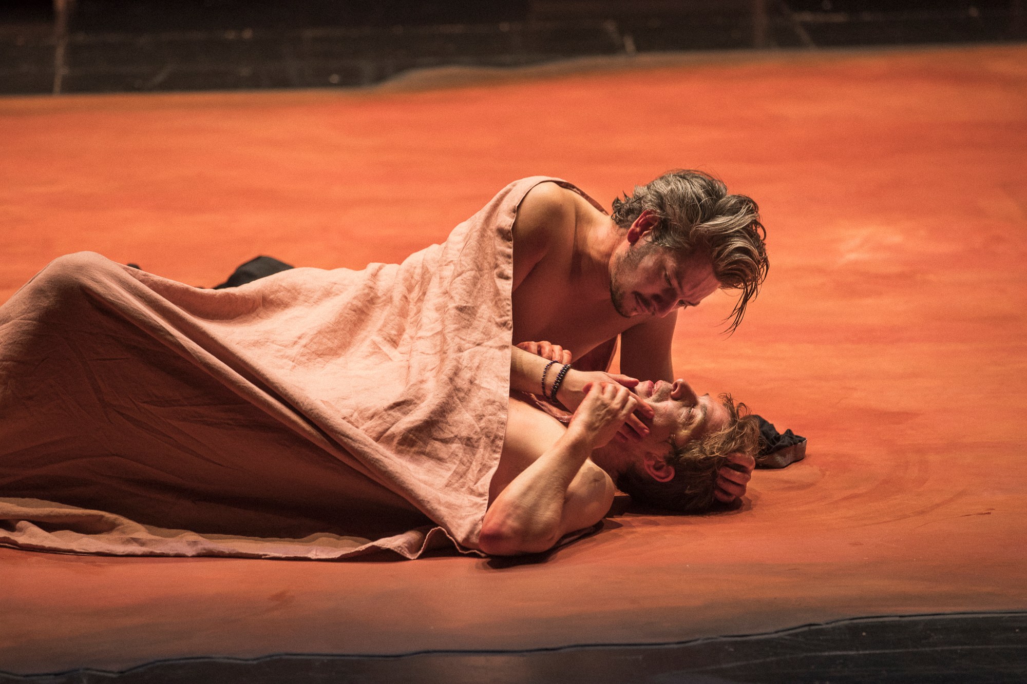 two actors lying on a stage under a blanket in a little life