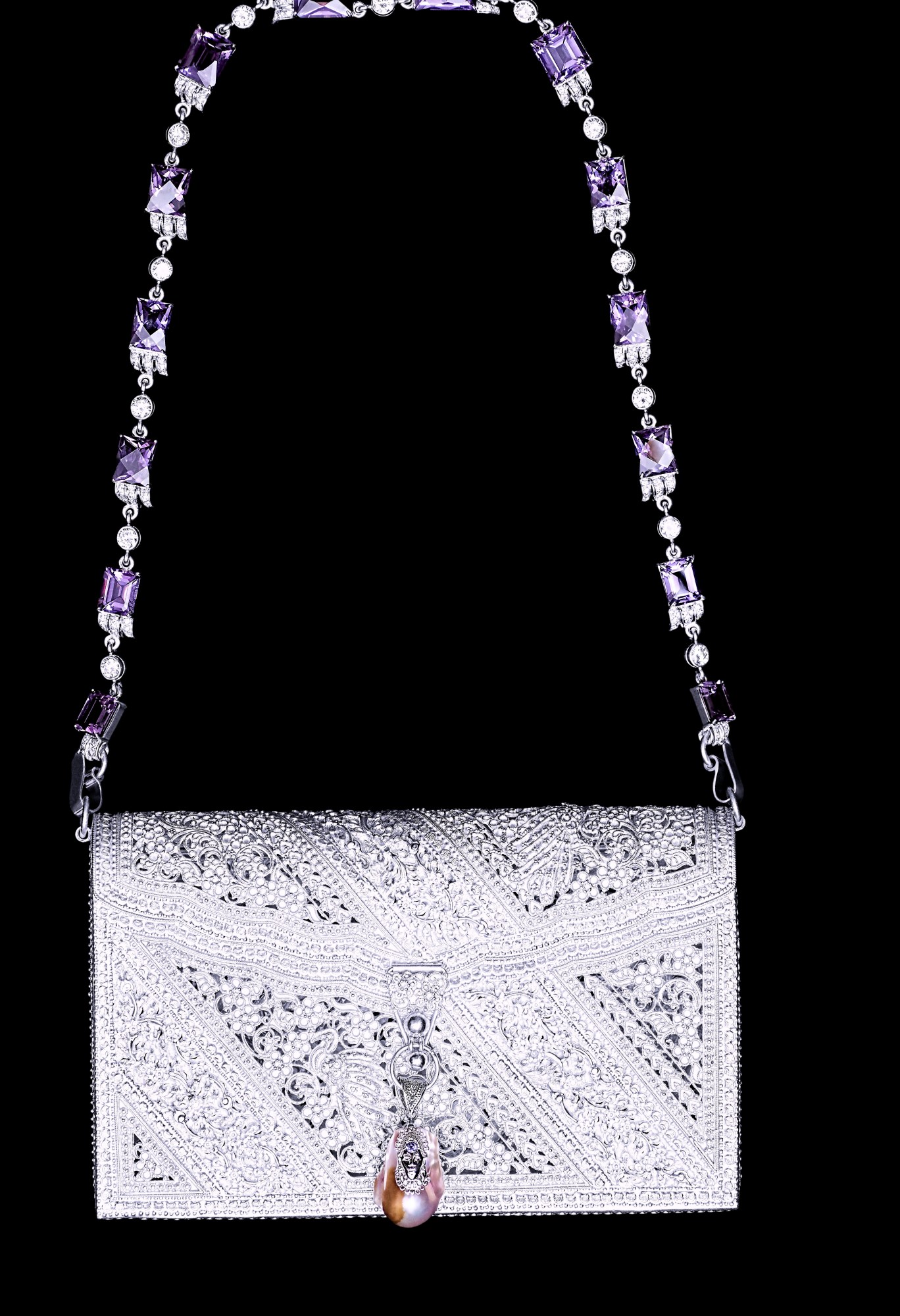 a silver engraved purse featuring amethysts against a black background